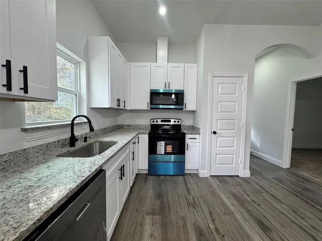 a kitchen with granite countertop a stove and a sink
