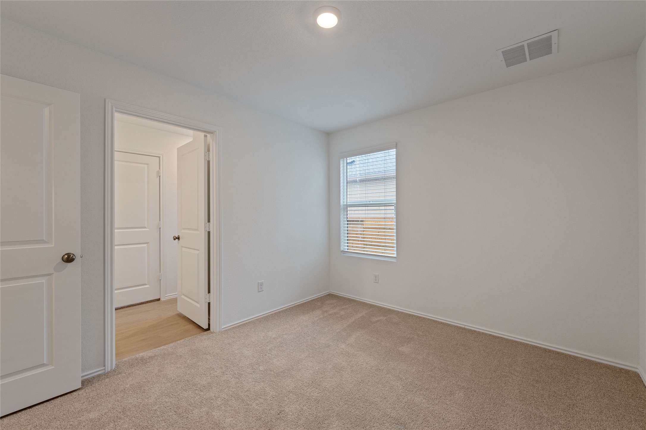 115 Parsons Kyle, TX 78640 - Photo 9 of 18 A well-lit bedroom with neutral carpet and ample natural illumination.