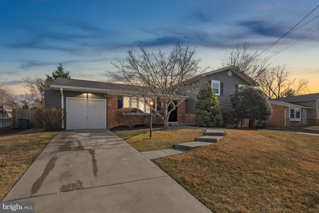 a backyard of a house with fountain and large tree