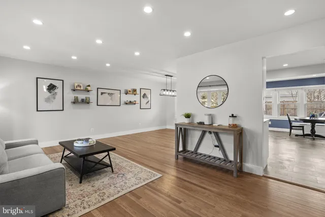 a living room with furniture a clock on wall and a table
