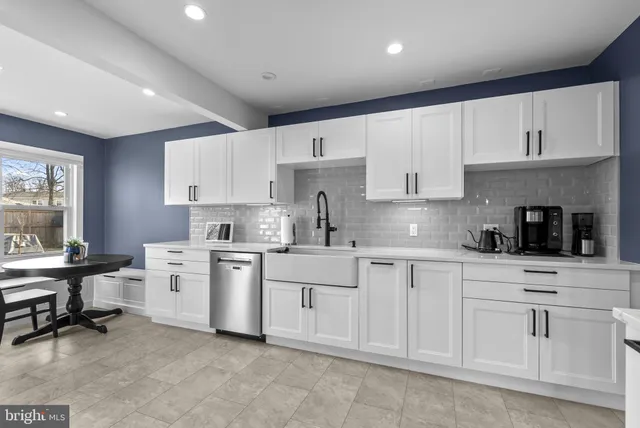a kitchen with white cabinets and white appliances