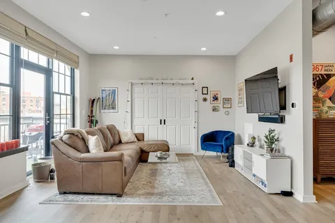 a living room with furniture a flat screen tv and a large window