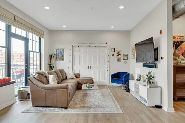 a living room with furniture a flat screen tv and a large window