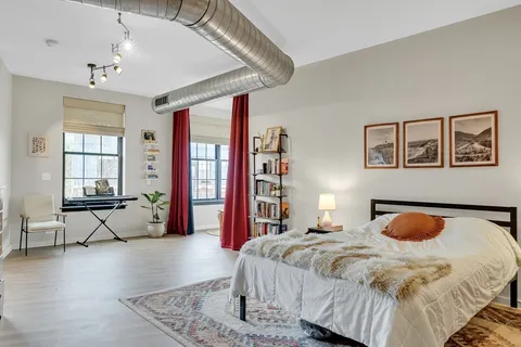 a bedroom with a bed and wooden floor