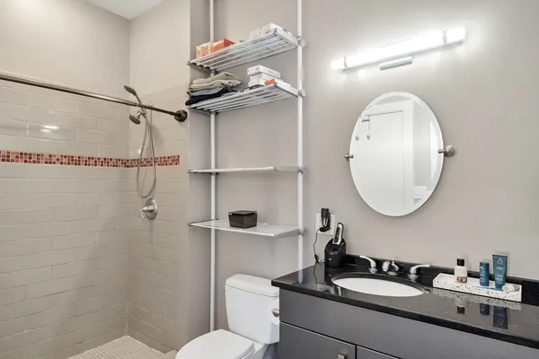 a bathroom with a sink a toilet and a mirror