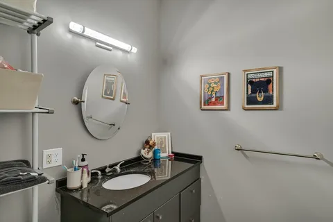 a bathroom with a sink mirror and a toilet