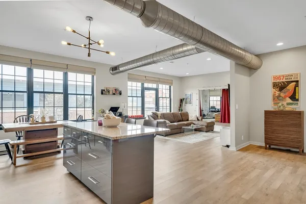 a kitchen with a stove a refrigerator and a view of living room
