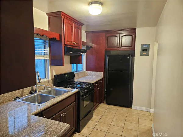 a kitchen with stainless steel appliances granite countertop a stove a refrigerator and a sink