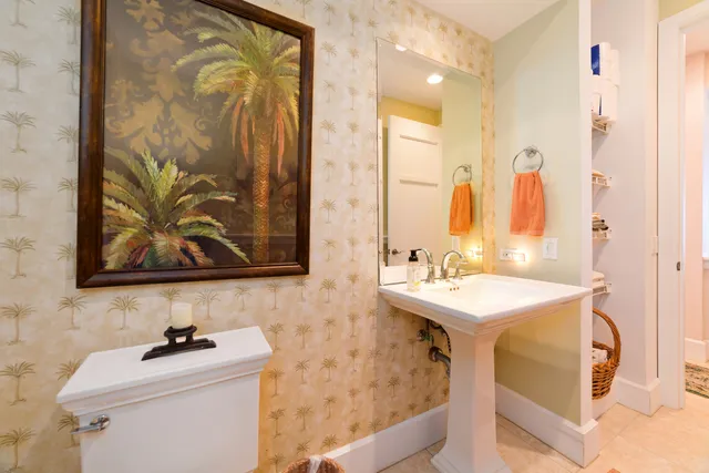 a bathroom with a sink mirror and a toilet
