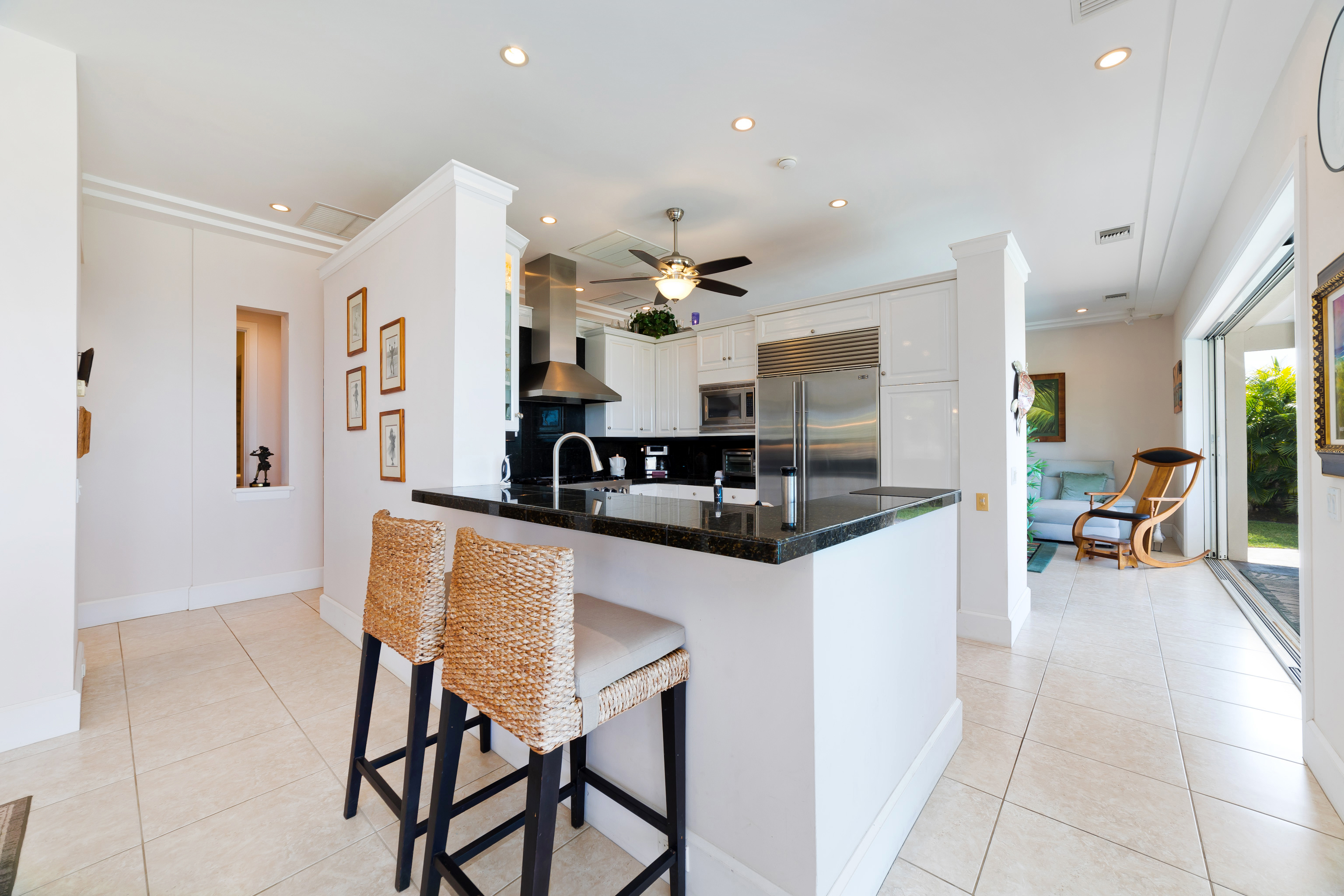 78-7018 Mololani Street Kailua-Kona, HI 96740 - Photo 18 of 30 a kitchen with stainless steel appliances kitchen island granite countertop a table and chairs in it