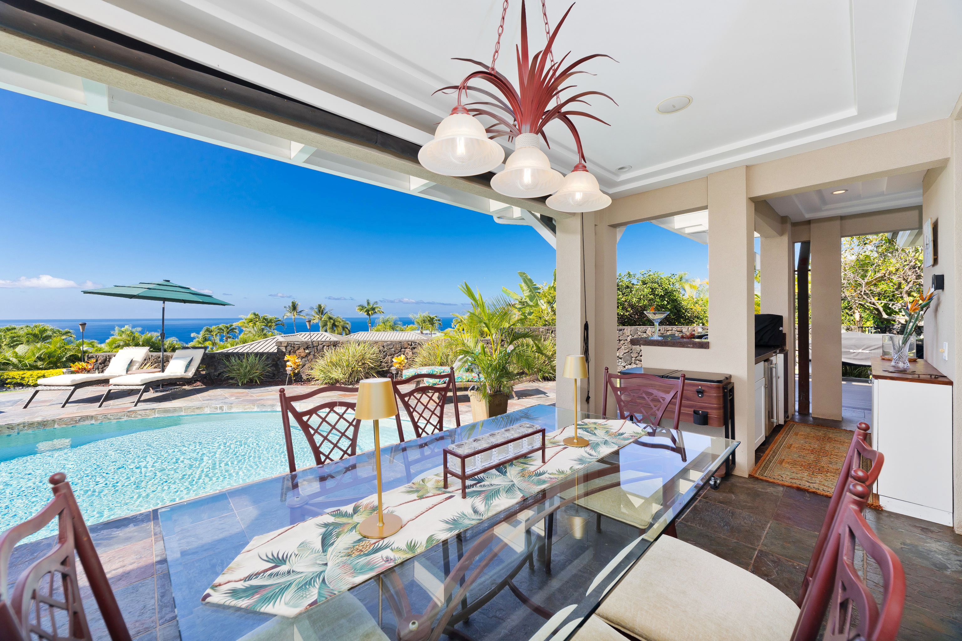 78-7018 Mololani Street Kailua-Kona, HI 96740 - Photo 22 of 30 a living room with furniture a chandelier and a dining table