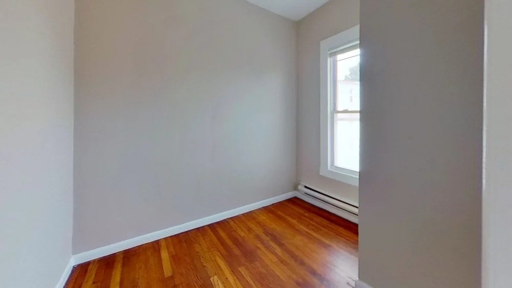 121 George Street, Unit 2 Boston, MA 02119 - Photo 4 of 8 an empty room with wooden floor and windows