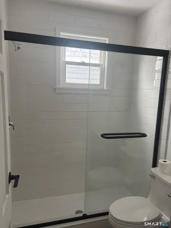 a bathroom with a toilet and a shower