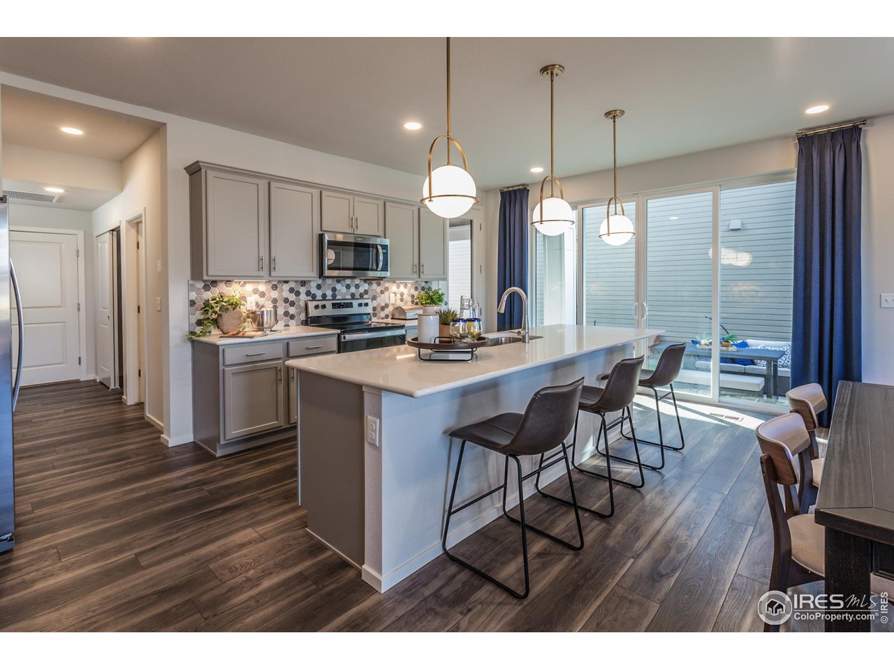 6101 Sublette Road Timnath, CO 80547 - Photo 10 of 34 a kitchen with stainless steel appliances a dining table chairs stove and cabinets