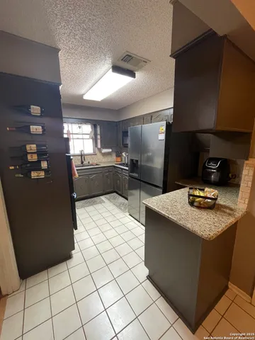 a kitchen with stainless steel appliances kitchen island granite countertop a refrigerator and a stove