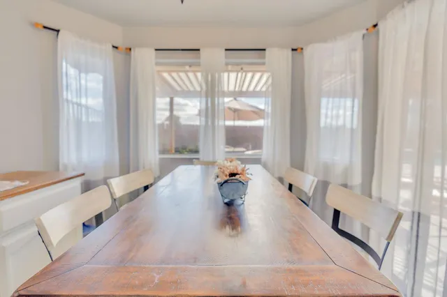 a view of a patio with a dining table and chairs with wooden floor