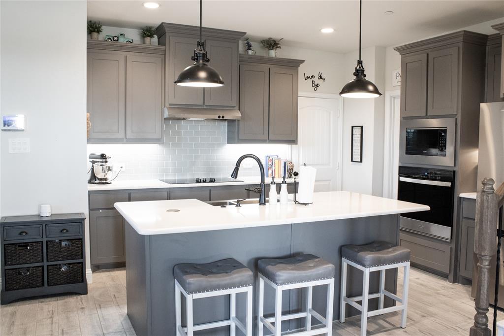 642 Sandiford Court Mansfield, TX 76063 - Photo 11 of 40 a kitchen with stainless steel appliances kitchen island a table chairs sink and cabinets