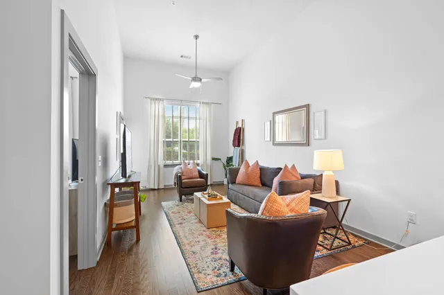 a living room with furniture and a wooden floor