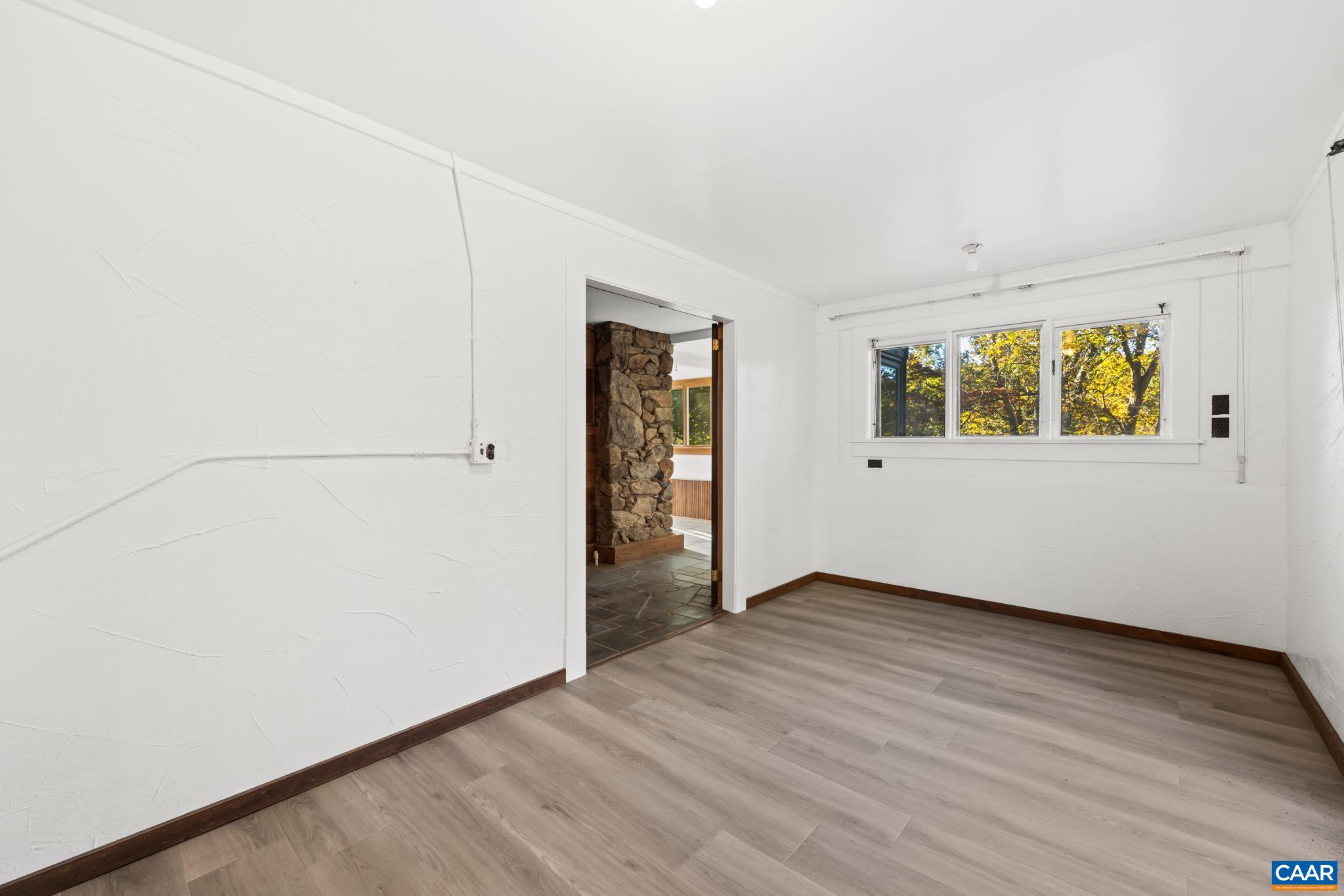 9712 Old Green Mountain Road Esmont, VA 22937 - Photo 40 of 42 an empty room with wooden floor and windows