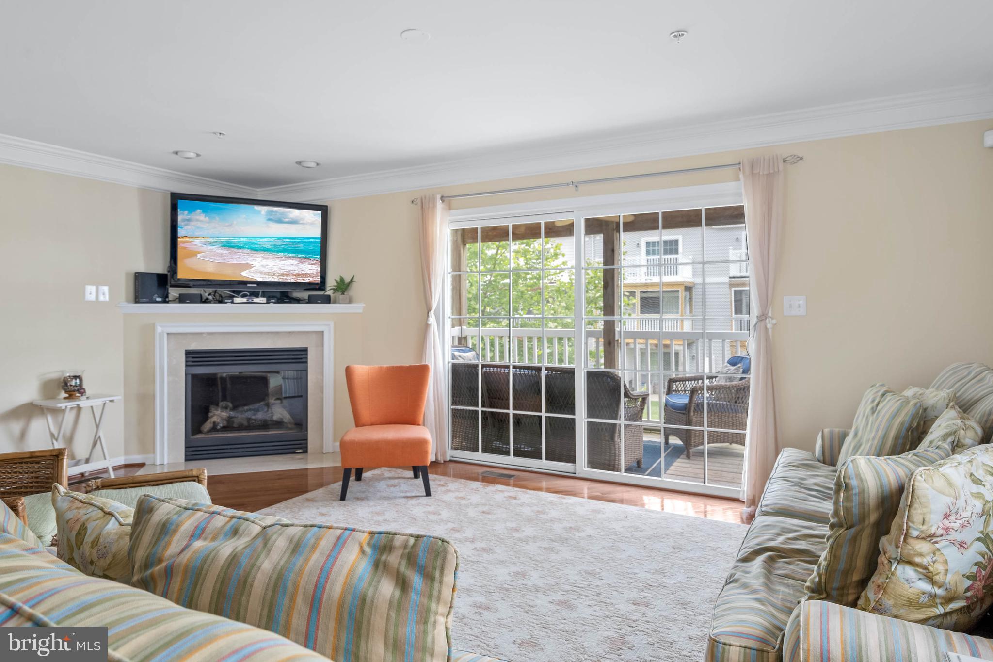 19901 Ames Drive, Unit 133 Rehoboth Beach, DE 19971 - Photo 13 of 34 a living room with furniture a fireplace and a flat screen tv