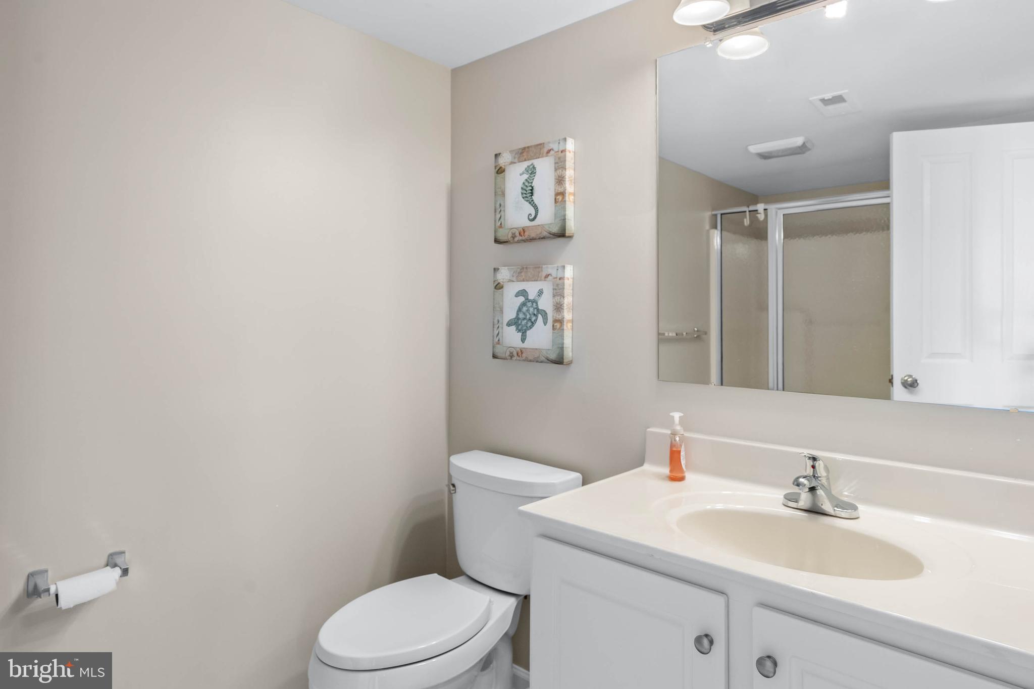 19901 Ames Drive, Unit 133 Rehoboth Beach, DE 19971 - Photo 15 of 34 a bathroom with a toilet a sink and mirror