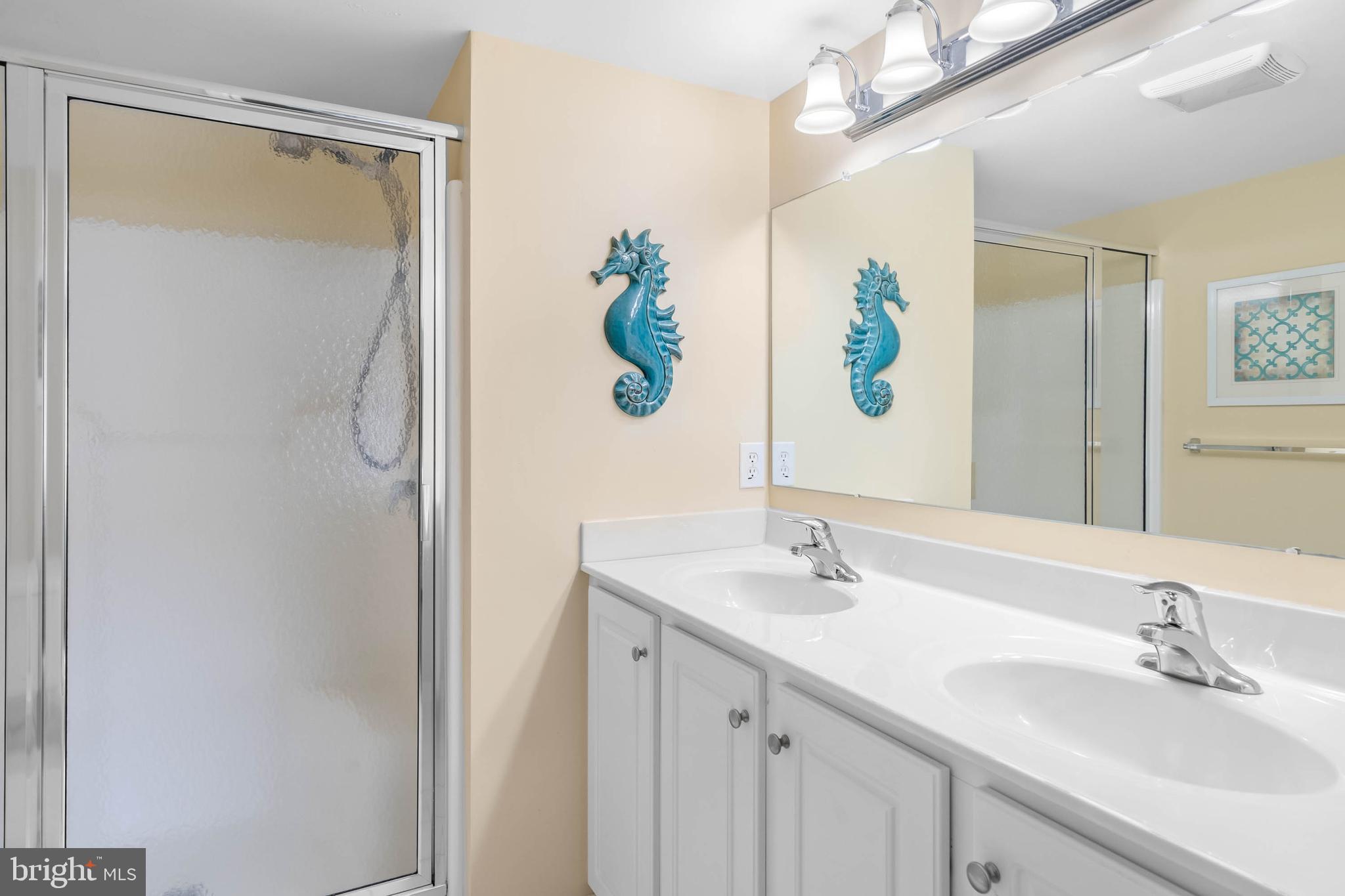 19901 Ames Drive, Unit 133 Rehoboth Beach, DE 19971 - Photo 21 of 34 a bathroom with a sink a mirror and a shower