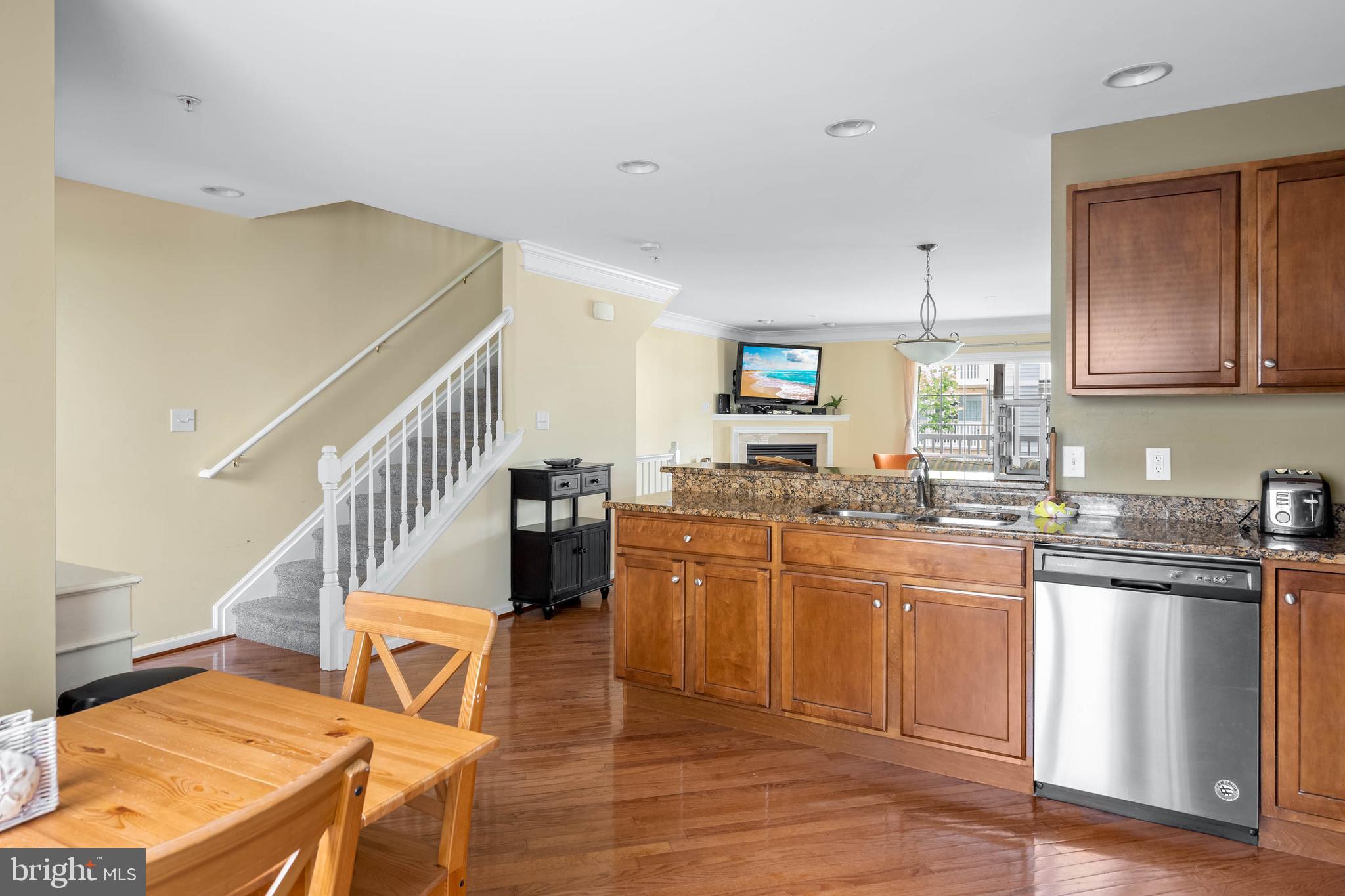 19901 Ames Drive, Unit 133 Rehoboth Beach, DE 19971 - Photo 7 of 34 a kitchen with stainless steel appliances granite countertop a stove a sink dishwasher and a refrigerator with wooden floor
