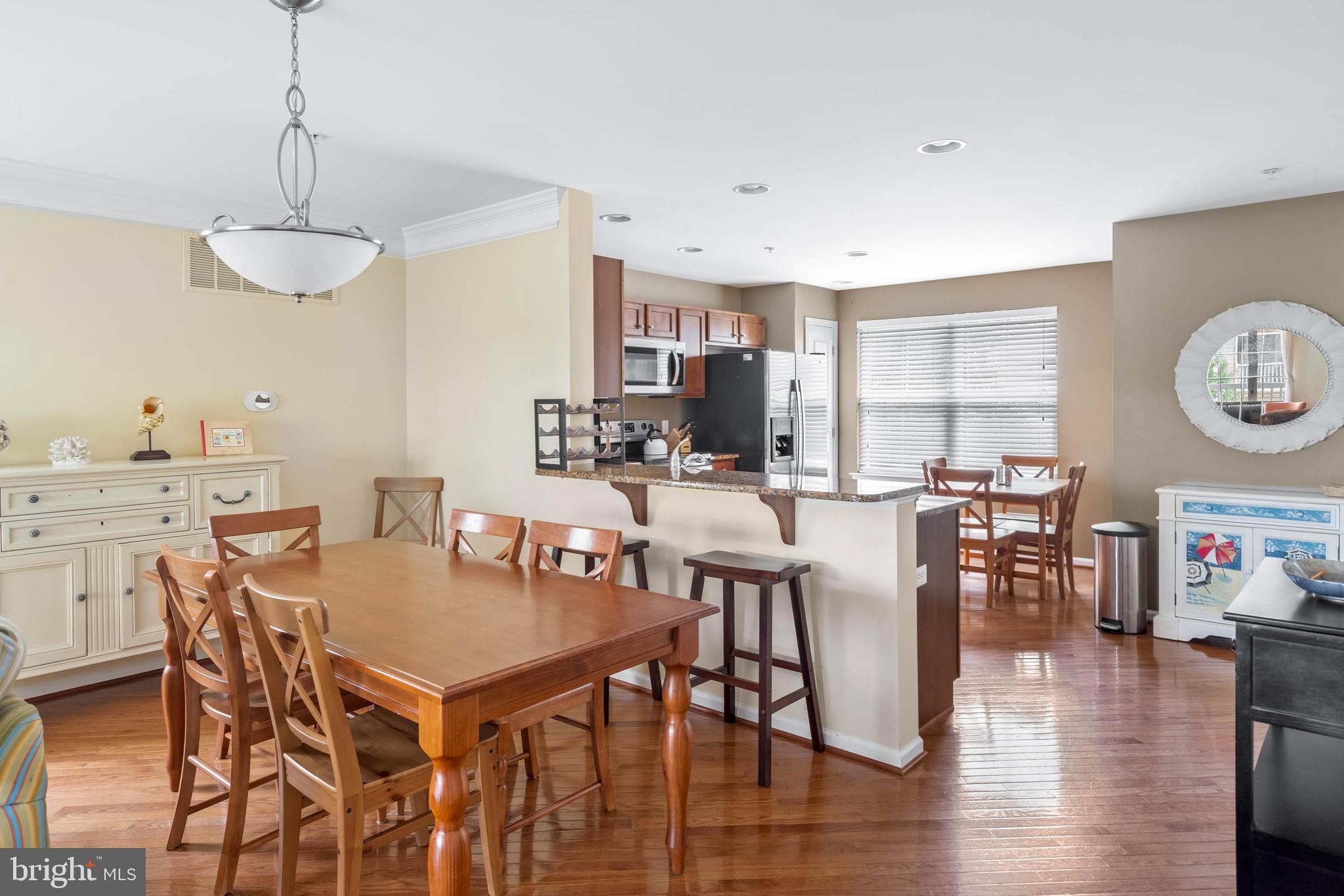 19901 Ames Drive, Unit 133 Rehoboth Beach, DE 19971 - Photo 10 of 34 a view of a dining room and livingroom with furniture wooden floor a chandelier