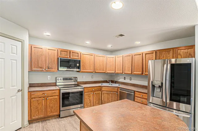 a kitchen with a sink a white cabinets and stainless steel appliances