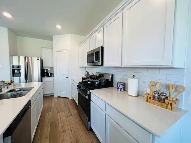 a kitchen with a sink stove top oven and refrigerator