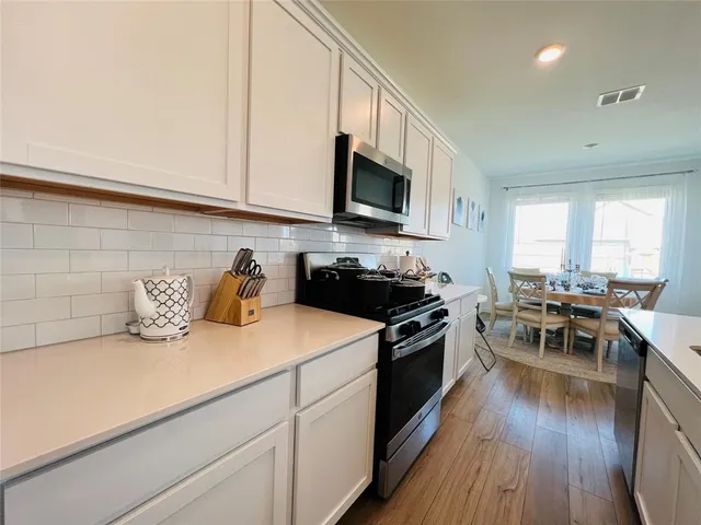 a kitchen with a sink a stove and cabinets