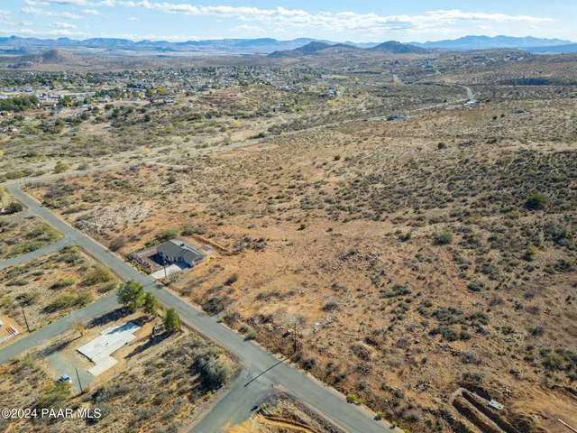 a view of a dry yard with mountains in the background