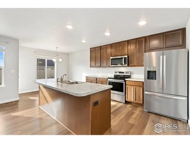 a kitchen with kitchen island granite countertop stainless steel appliances and refrigerator