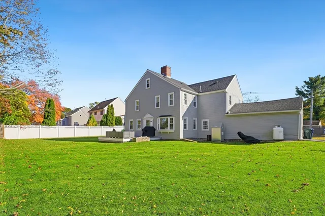 front view of a house with a yard and a large tree