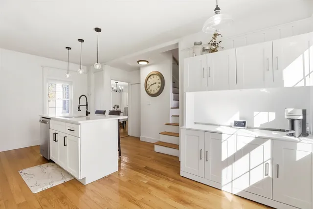a kitchen with a sink cabinets and wooden floor