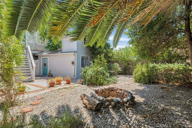 a view of a backyard with plants and a lawn chairs