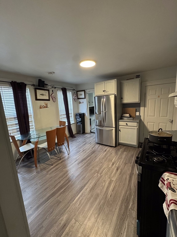 99 Clover Street Worcester, MA 01603 - Photo 6 of 8 a kitchen with granite countertop a refrigerator stove and wooden floor