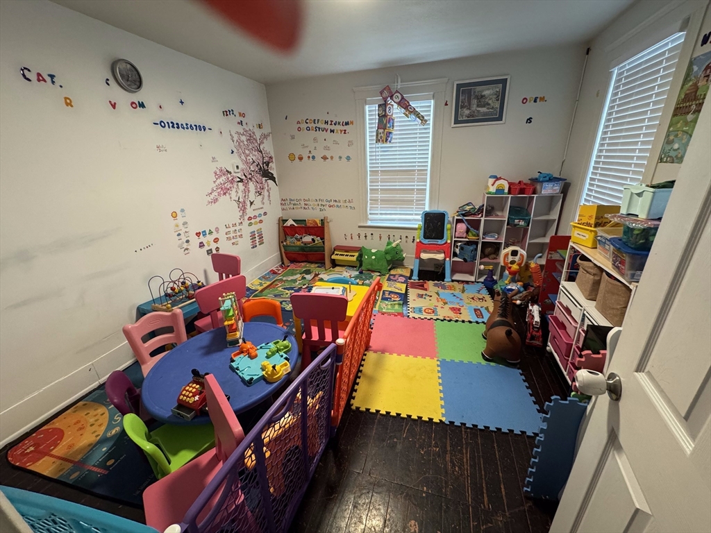 99 Clover Street Worcester, MA 01603 - Photo 7 of 8 a living room with furniture a baby crib and a couch
