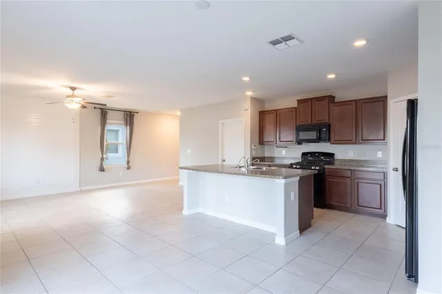 a large kitchen with a large counter top stainless steel appliances and cabinets