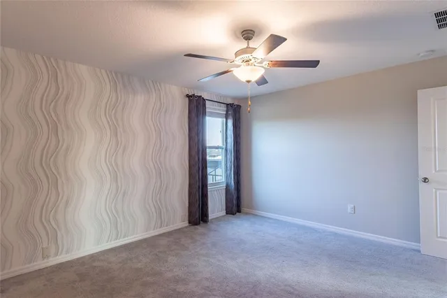 an empty room with a fan and a fan