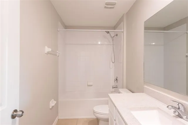 a view of an empty room with window and chandelier fan
