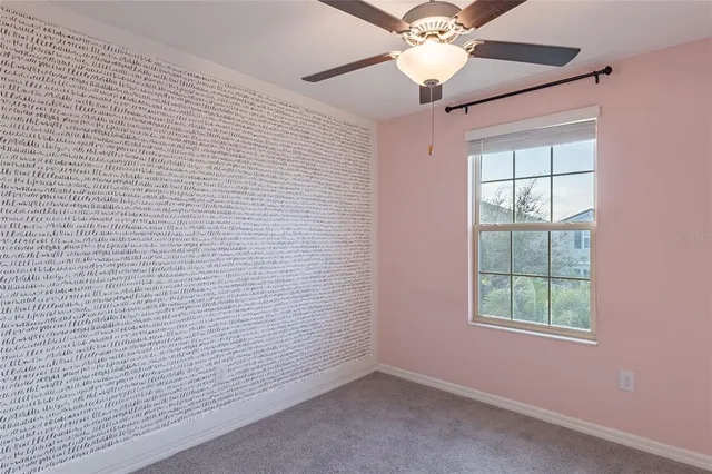 an empty room with windows and fan