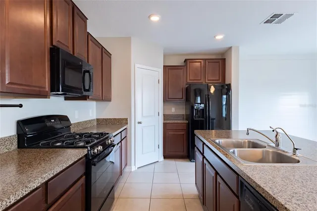 a kitchen with granite countertop a sink stove and refrigerator