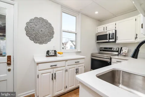 a kitchen with stainless steel appliances a sink a stove and microwave