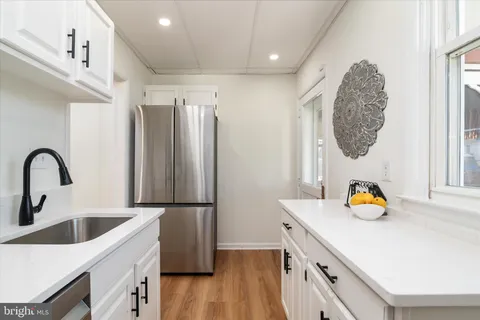 a kitchen with a refrigerator sink and white cabinets