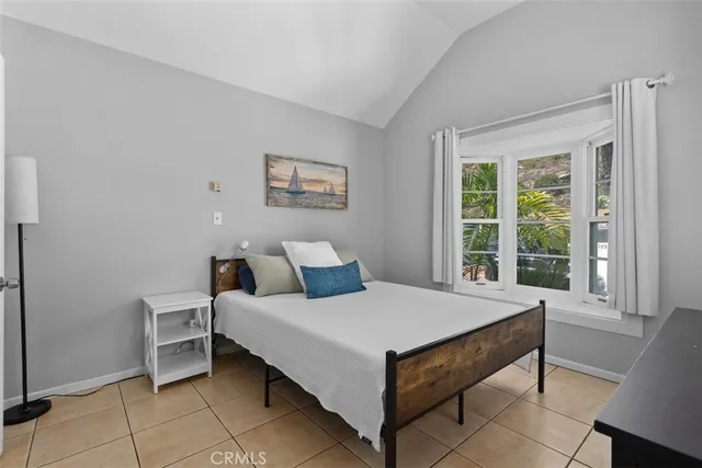 a large bed sitting in a bedroom next to a window