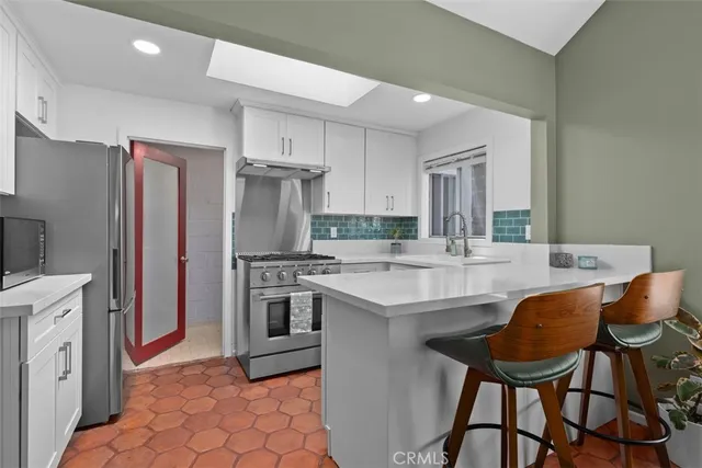 a kitchen with stainless steel appliances granite countertop a sink stove and refrigerator