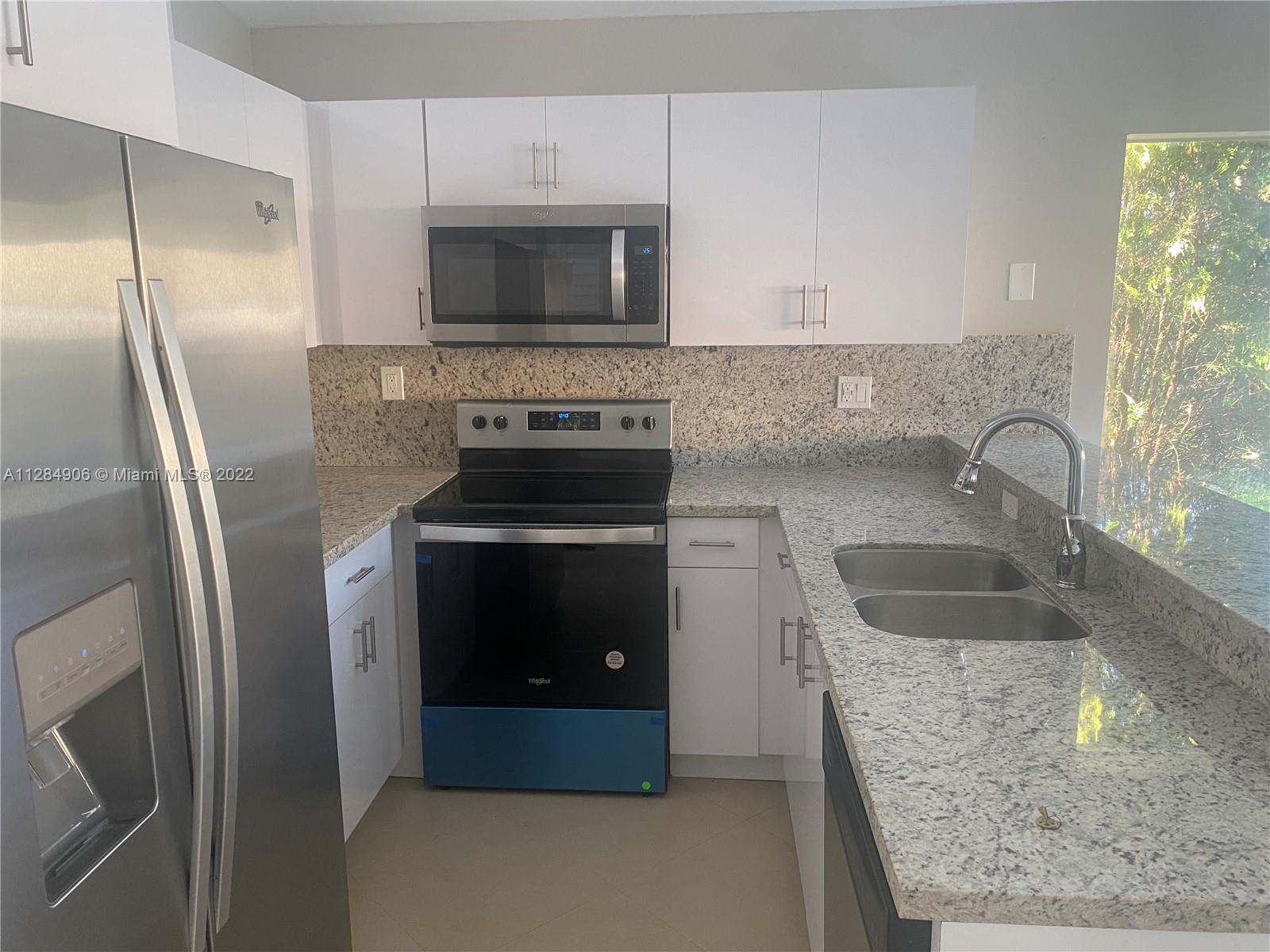 17501 Southwest 142nd Court Miami, FL 33177 - Photo 7 of 8 a kitchen with stainless steel appliances granite countertop a refrigerator a stove a sink and a oven