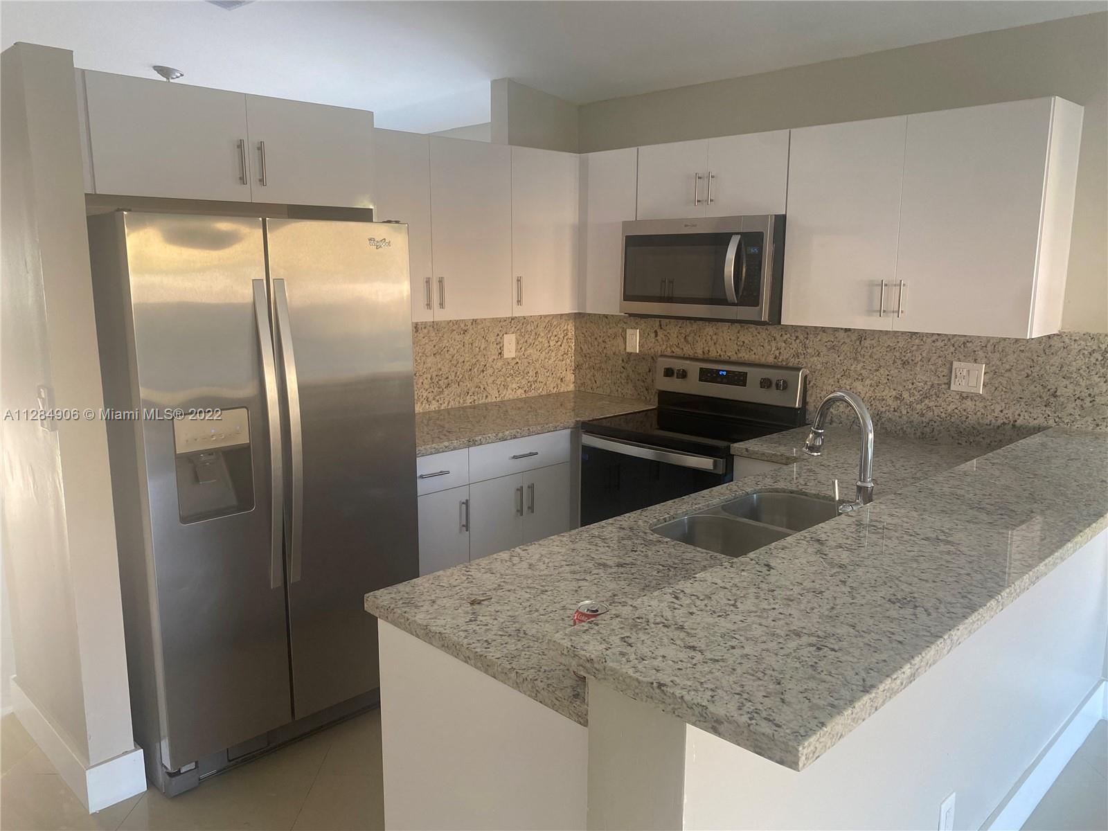 17501 Southwest 142nd Court Miami, FL 33177 - Photo 8 of 8 a kitchen with stainless steel appliances granite countertop a sink and a refrigerator