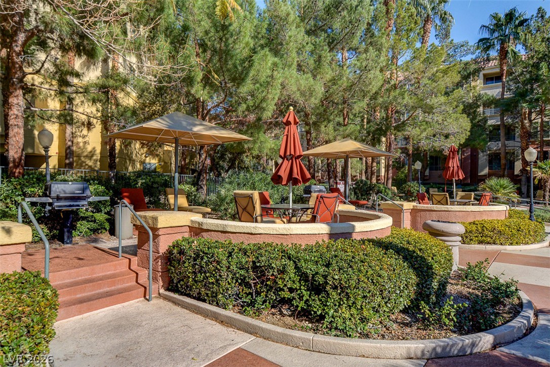 210 East Flamingo Road, Unit 208 Las Vegas, NV 89169 - Photo 38 of 42 Lush landscaping and shaded seating define this inviting community outdoor space, perfect for relaxing.